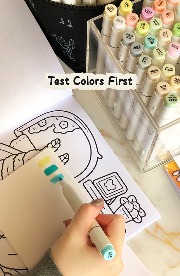 Testing marker colors on paper before coloring the main area